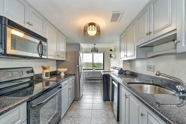 49 Melrose St Unit 7F, Melrose, MA 02176 - kitchen with appliances with stainless steel finishes, tasteful backsplash, dark stone countertops, and washer / dryer