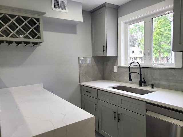 54 Federal St, Weymouth, MA 02188 - kitchen with stainless steel dishwasher, a sink, gray cabinetry, decorative backsplash, and light stone countertops