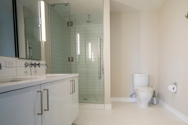 bathroom featuring toilet, vanity, tile patterned floors, and a shower with door