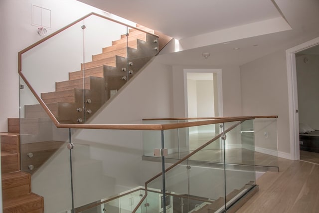 staircase with hardwood / wood-style floors