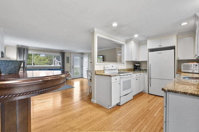 kitchen with white appliances, white cabinets, dark stone countertops, and ornamental molding