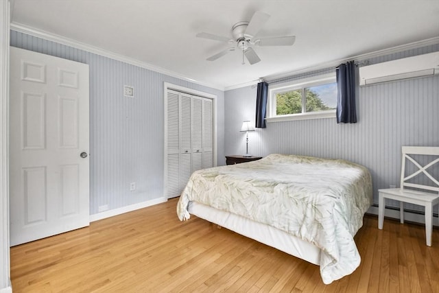 bedroom with a wall mounted AC, a closet, ceiling fan, ornamental molding, and wood-type flooring