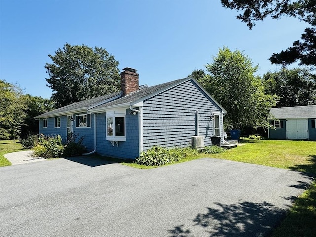 view of side of property with a yard and a shed