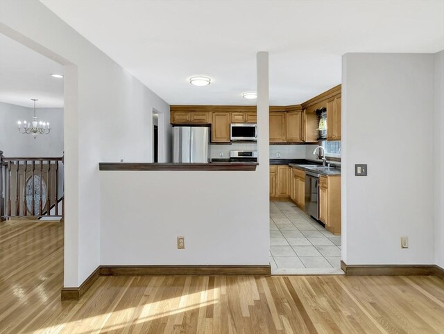 kitchen with dark stone countertops, light tile patterned floors, stainless steel appliances, and tasteful backsplash