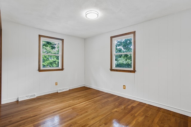 unfurnished room with hardwood / wood-style flooring and a textured ceiling