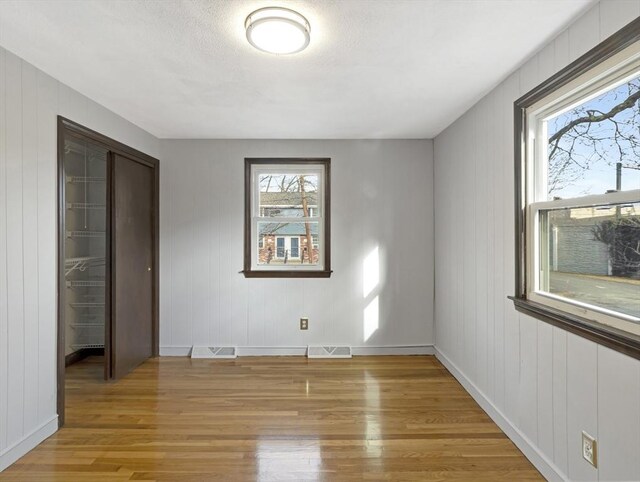 basement with wooden walls, crown molding, and a textured ceiling