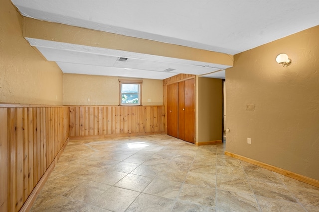 unfurnished room featuring wood walls and tile patterned flooring