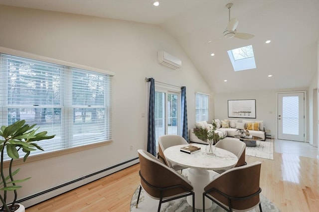 dining room featuring a skylight, ceiling fan, baseboard heating, light hardwood / wood-style floors, and a wall unit AC