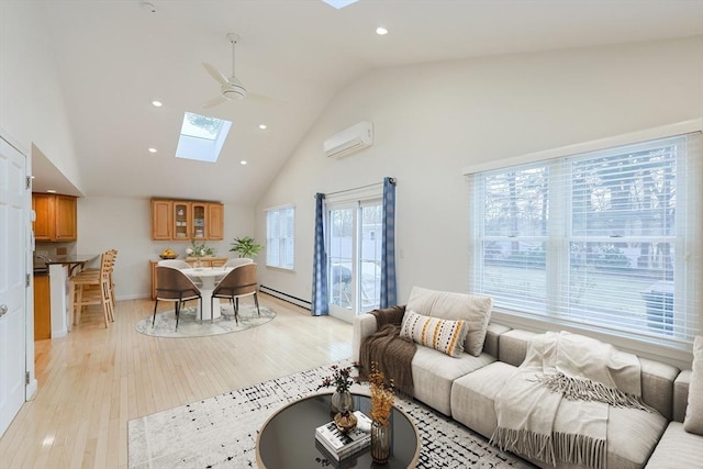 living room featuring a skylight, ceiling fan, a wall mounted air conditioner, high vaulted ceiling, and light hardwood / wood-style floors