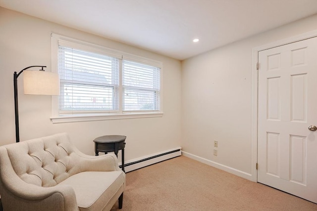 sitting room featuring light colored carpet and a baseboard heating unit