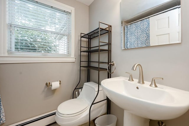 bathroom featuring toilet, curtained shower, sink, and a baseboard heating unit