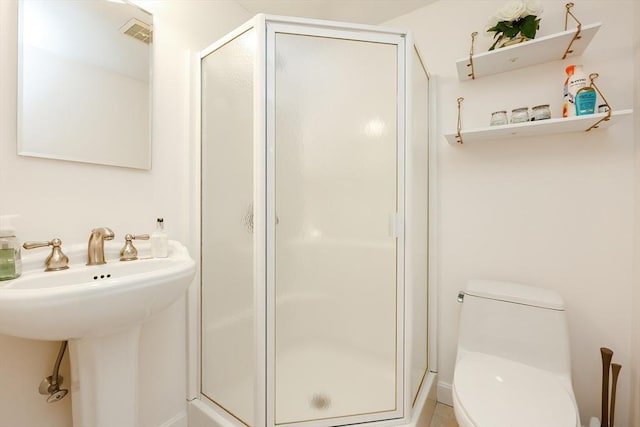 bathroom with toilet and a shower with shower door