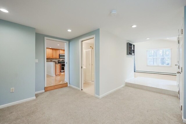 hallway with light colored carpet and a baseboard radiator