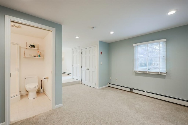 carpeted bedroom with connected bathroom and a baseboard radiator