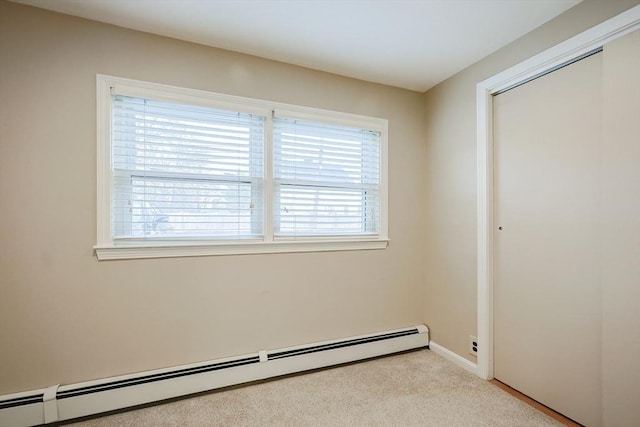 empty room with light colored carpet and a baseboard heating unit