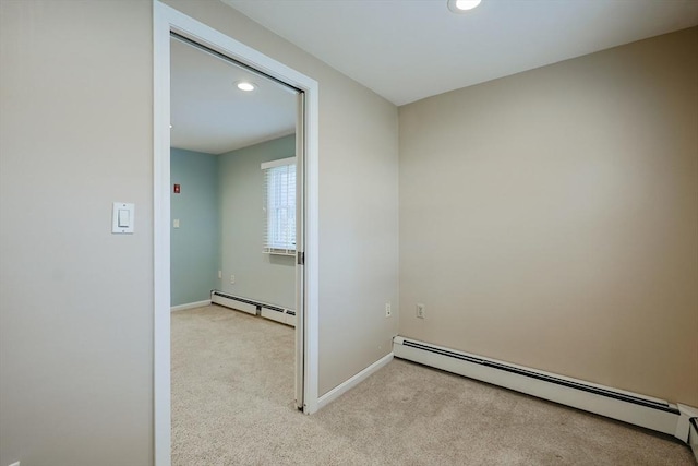 hall featuring light colored carpet and a baseboard heating unit