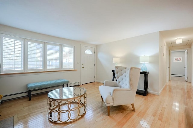 sitting room with baseboard heating and light hardwood / wood-style floors