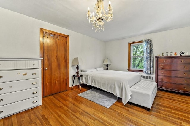 bedroom with a chandelier, wood finished floors, and radiator