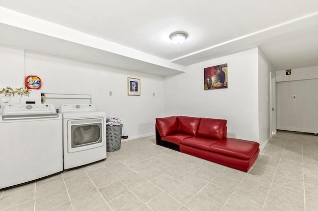 clothes washing area featuring washing machine and clothes dryer, light tile patterned floors, and baseboards