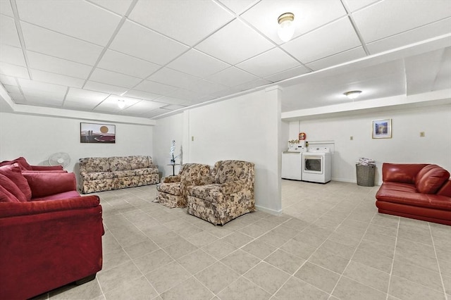living area featuring a drop ceiling, light tile patterned flooring, and baseboards