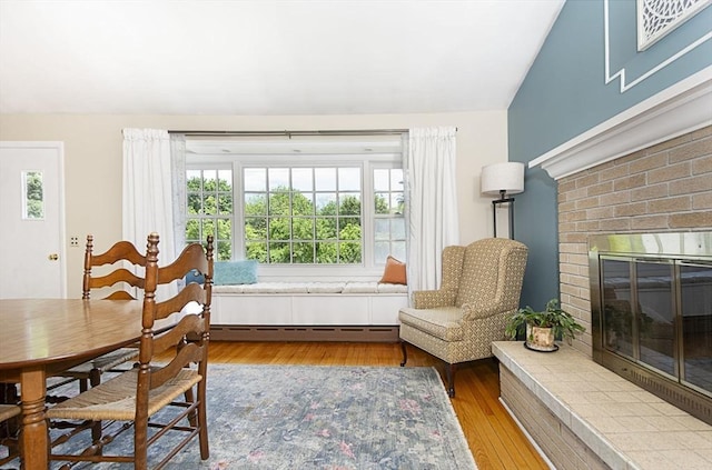 12 Crosby, Webster, MA 01570 - dining room featuring lofted ceiling, baseboard heating, a fireplace, and wood finished floors