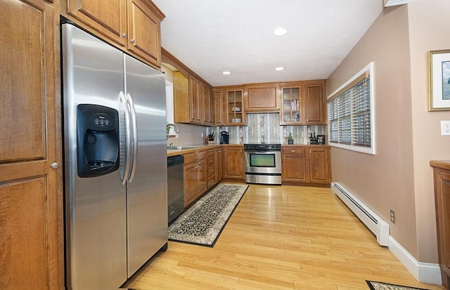 12 Crosby, Webster, MA 01570 - kitchen featuring appliances with stainless steel finishes, a baseboard radiator, brown cabinetry, light wood finished floors, and a sink