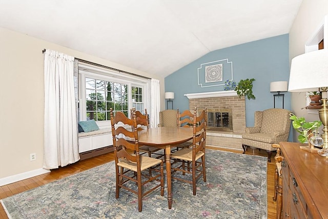 12 Crosby, Webster, MA 01570 - dining room with wood finished floors, vaulted ceiling, a brick fireplace, and baseboards