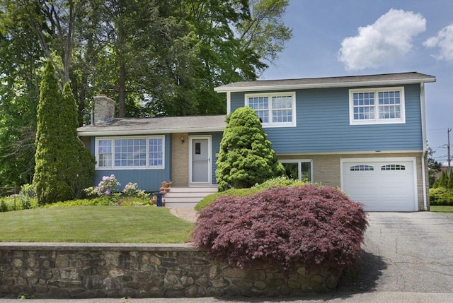 12 Crosby, Webster, MA 01570 - tri-level home featuring a chimney, an attached garage, driveway, a front yard, and brick siding