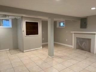 basement featuring electric panel and light tile patterned floors