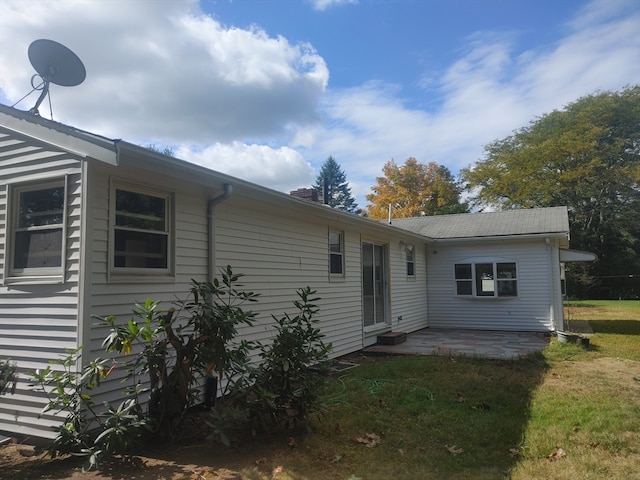 rear view of property with a lawn and a patio area