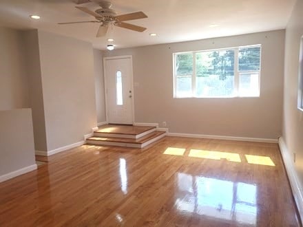 foyer featuring baseboard heating, hardwood / wood-style floors, and ceiling fan