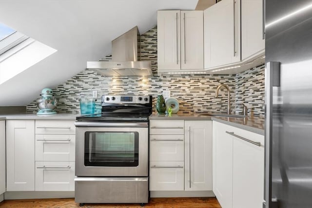 kitchen featuring white cabinets, appliances with stainless steel finishes, island exhaust hood, tasteful backsplash, and sink