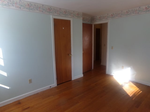 unfurnished room with wood-type flooring