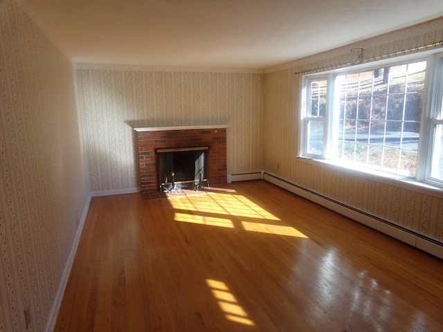 unfurnished living room featuring hardwood / wood-style floors, a fireplace, and a baseboard radiator