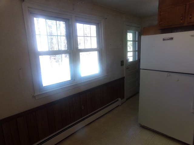 kitchen with baseboard heating and white fridge