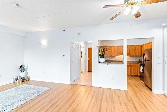 200 Cove Way Unit 106, Quincy, MA 02169 - kitchen featuring freestanding refrigerator, open floor plan, brown cabinetry, light wood finished floors, and a ceiling fan