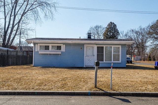 view of front of house featuring a front lawn and fence