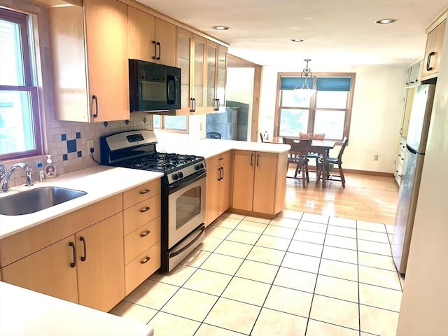52 Burnett St, Granby, MA 01033 - kitchen featuring black microwave, stainless steel range with gas stovetop, a sink, a peninsula, and light countertops