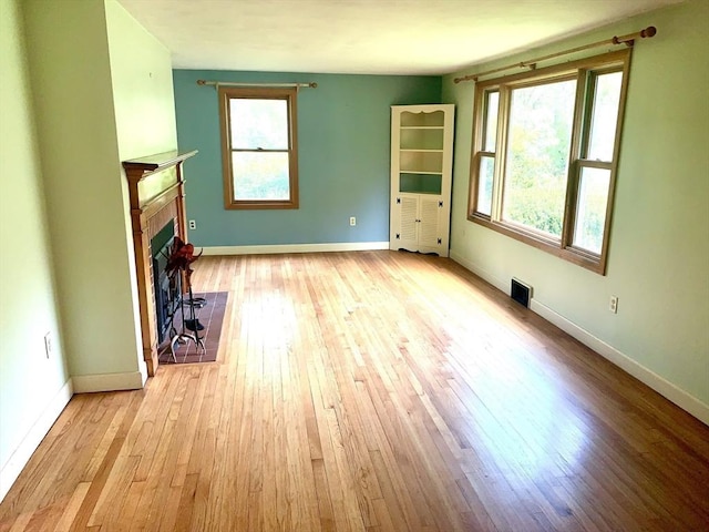 52 Burnett St, Granby, MA 01033 - unfurnished living room with plenty of natural light, wood-type flooring, a tile fireplace, and baseboards