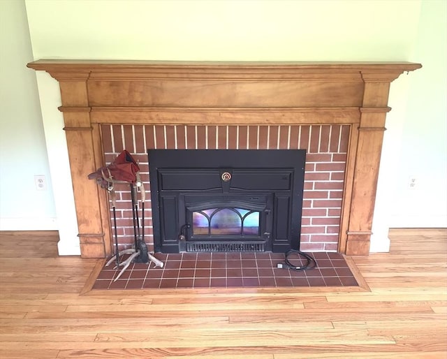 52 Burnett St, Granby, MA 01033 - detailed view of a brick fireplace, wood finished floors, and baseboards