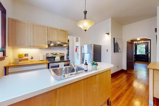 140 Highland Ave Unit 1, Somerville, MA 02143 - kitchen with appliances with stainless steel finishes, under cabinet range hood, a sink, arched walkways, and light wood-style floors