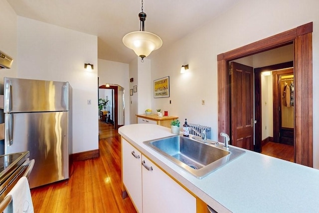 140 Highland Ave Unit 1, Somerville, MA 02143 - kitchen with a sink, appliances with stainless steel finishes, light wood-style flooring, and white cabinets