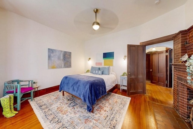 140 Highland Ave Unit 1, Somerville, MA 02143 - bedroom featuring a fireplace, arched walkways, wood finished floors, and ceiling fan