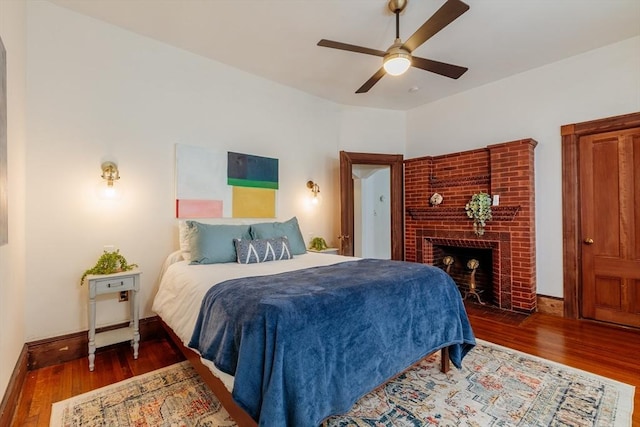 140 Highland Ave Unit 1, Somerville, MA 02143 - bedroom featuring wood finished floors, baseboards, a brick fireplace, and ceiling fan