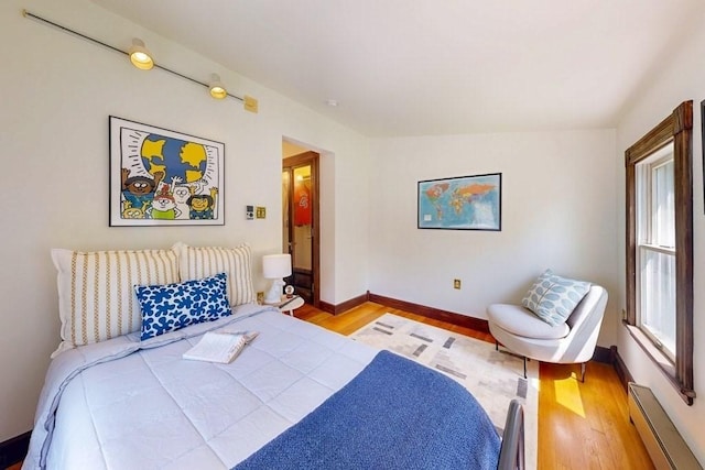 140 Highland Ave Unit 1, Somerville, MA 02143 - bedroom featuring baseboard heating, wood finished floors, and baseboards