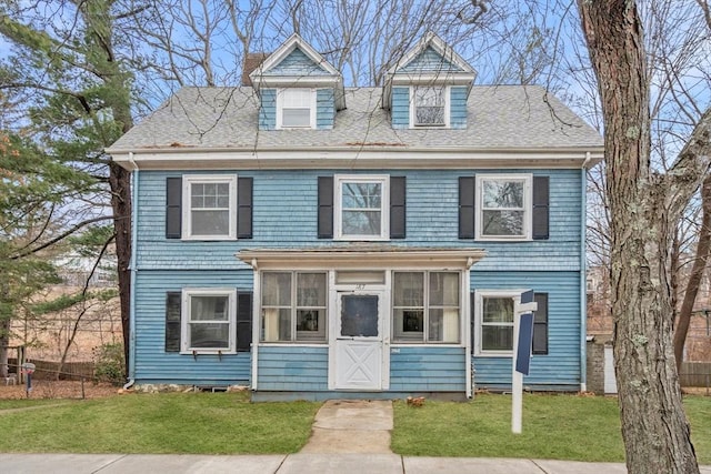 view of front of property with a front yard and a sunroom