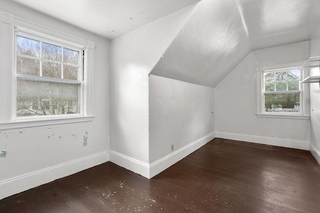 additional living space featuring vaulted ceiling, baseboards, and wood finished floors