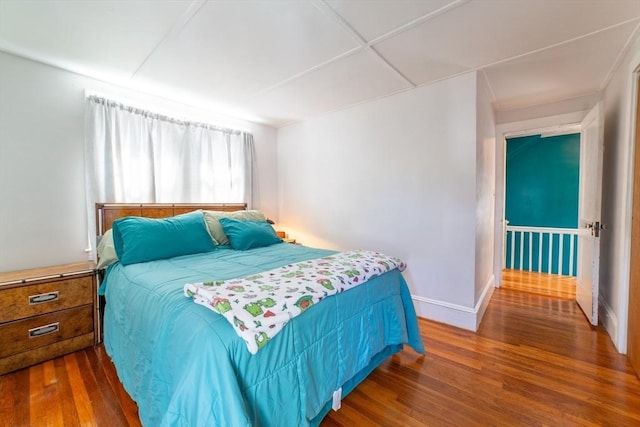 bedroom featuring baseboards and wood finished floors