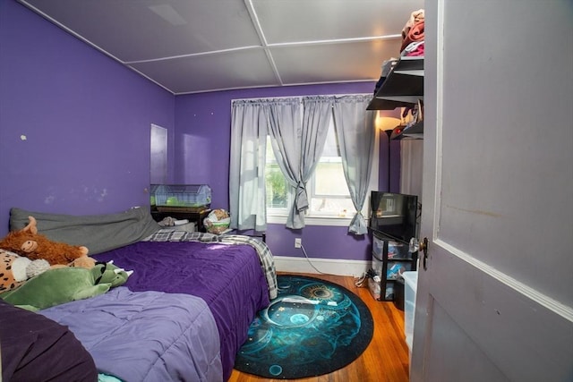 bedroom with baseboards and wood finished floors