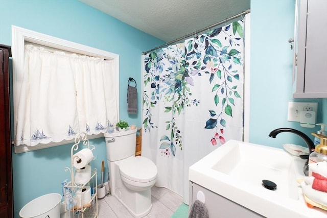 bathroom featuring toilet, a textured ceiling, curtained shower, and vanity